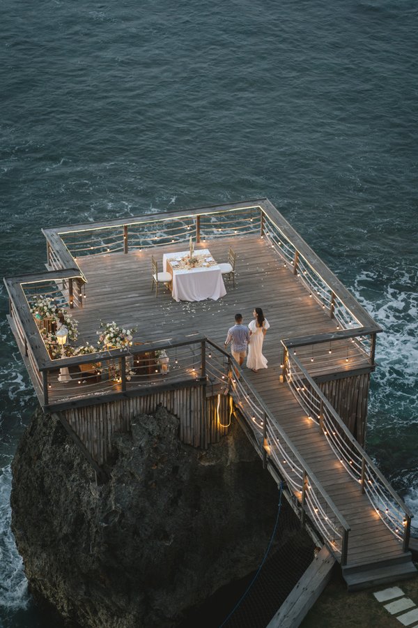 Private cliffside dinner setup above the ocean in Bali